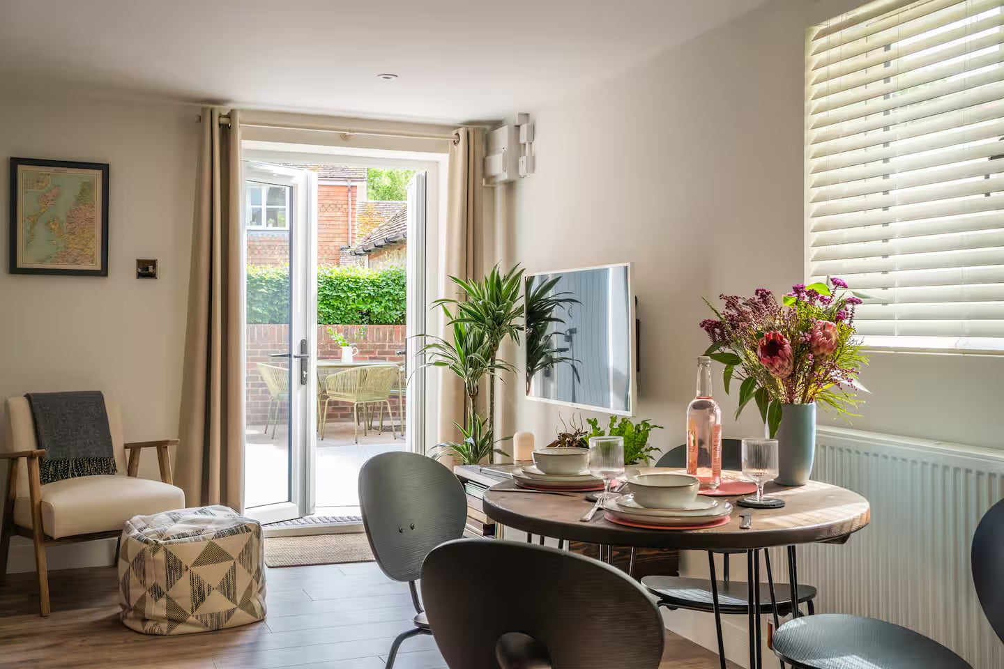 Solid wood dining table and shelving in a well styled Airbnb interior with warm lighting and natural materials