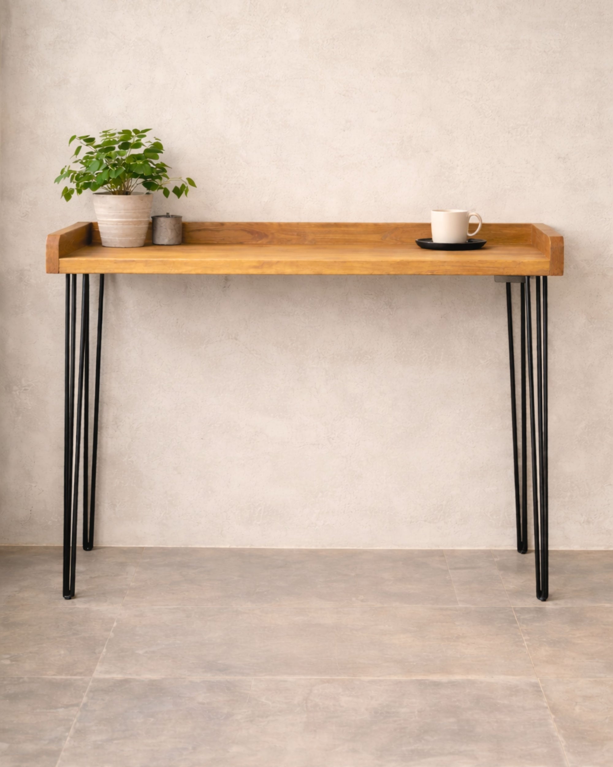Handmade solid wood breakfast bar table with black hairpin legs, styled with a plant and coffee cup against a neutral wall.